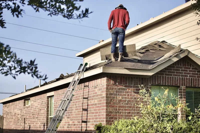 Professional roofer working on a residential roof in Brownfield